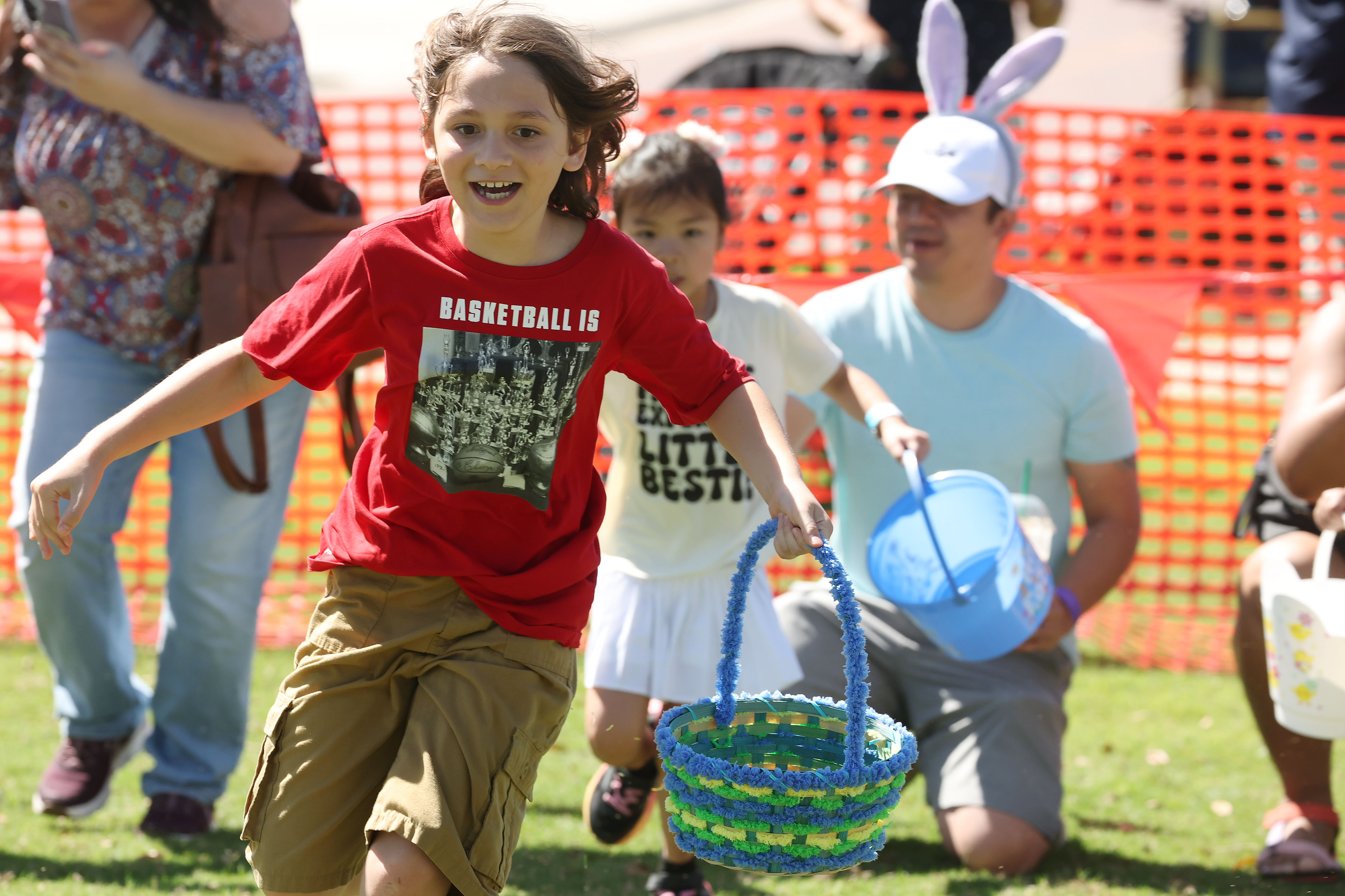 Children scurry to grab Easter eggs and candies from the...