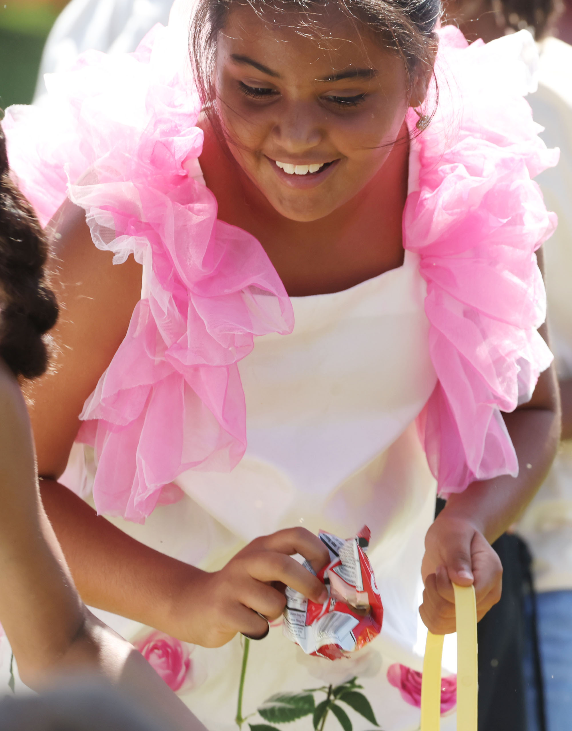 A girl holds goodeis collected at an Easter egg hunt...