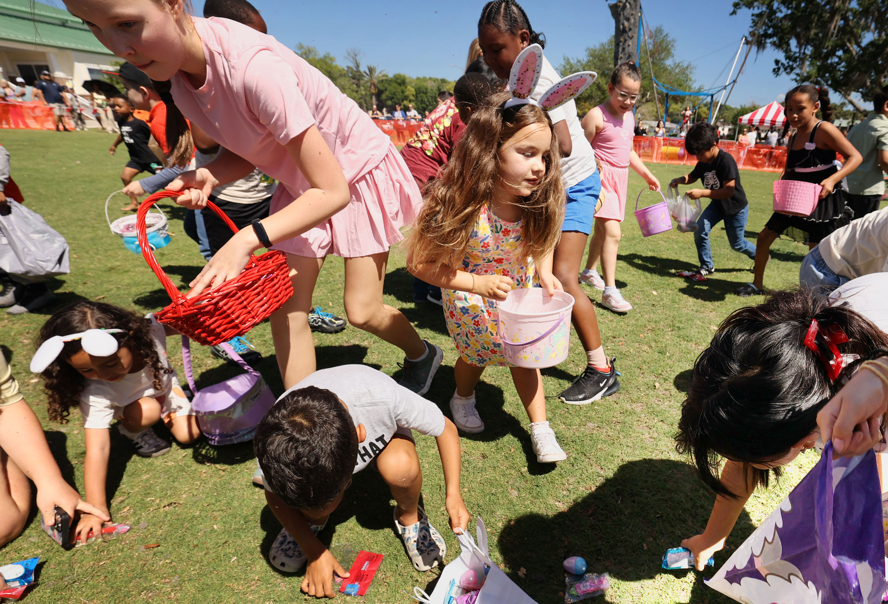 Children scurry to grab Easter eggs and candies from the...