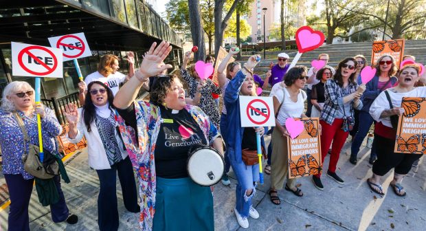 Pastor Sarah Robinson of Audubon Park Church leads protesters in song outside the Orange County Administration building in downtown Orlando, Tuesday, March 10, 2026. The county commission was scheduled to vote Tuesday on a resolution opposing plans to convert an Orange County warehouse into an Immigration and Customs Enforcement detention facility. (Joe Burbank/Orlando Sentinel)