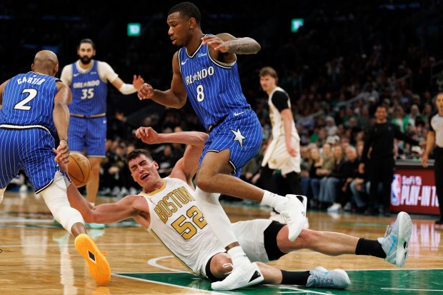 BOSTON, MASSACHUSETTS: Boston Celtics center Luka Garza center, is tripped up by Orlando Magic forward Jamal Cain right, during the second half against the Orlando Magic at the TD Garden on April 12 2026. (CJ Gunther/Boston Herald)