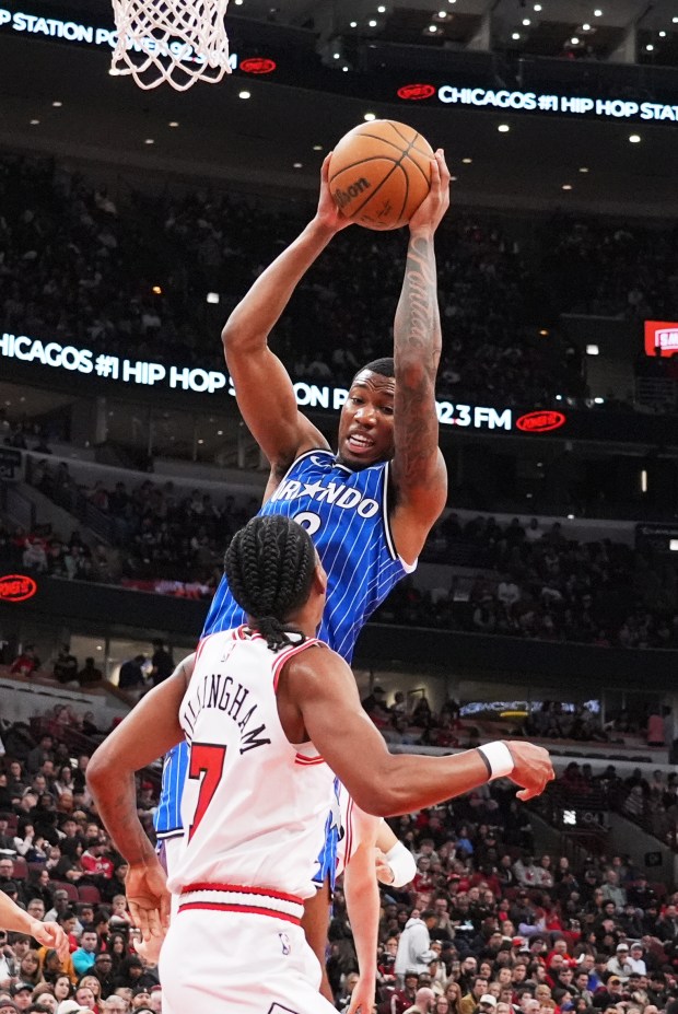 Orlando Magic forward Jamal Cain, top, rebounds a ball against Chicago Bulls guard Rob Dillingham during the first half of an NBA basketball game in Chicago, Friday, April 10, 2026. (AP Photo/Nam Y. Huh)