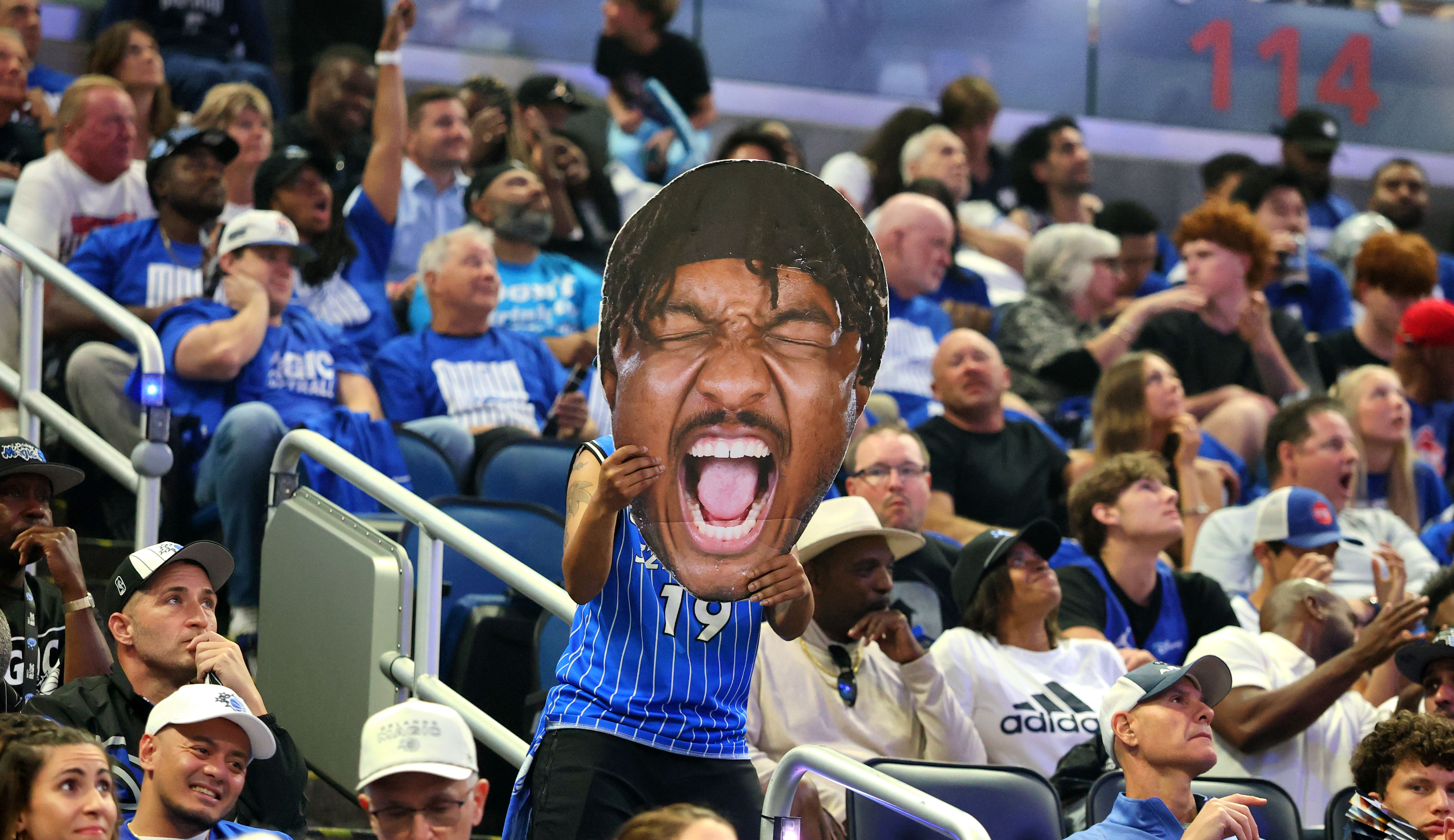 An Orlando Magic fan holds up a cutout of Wendell...