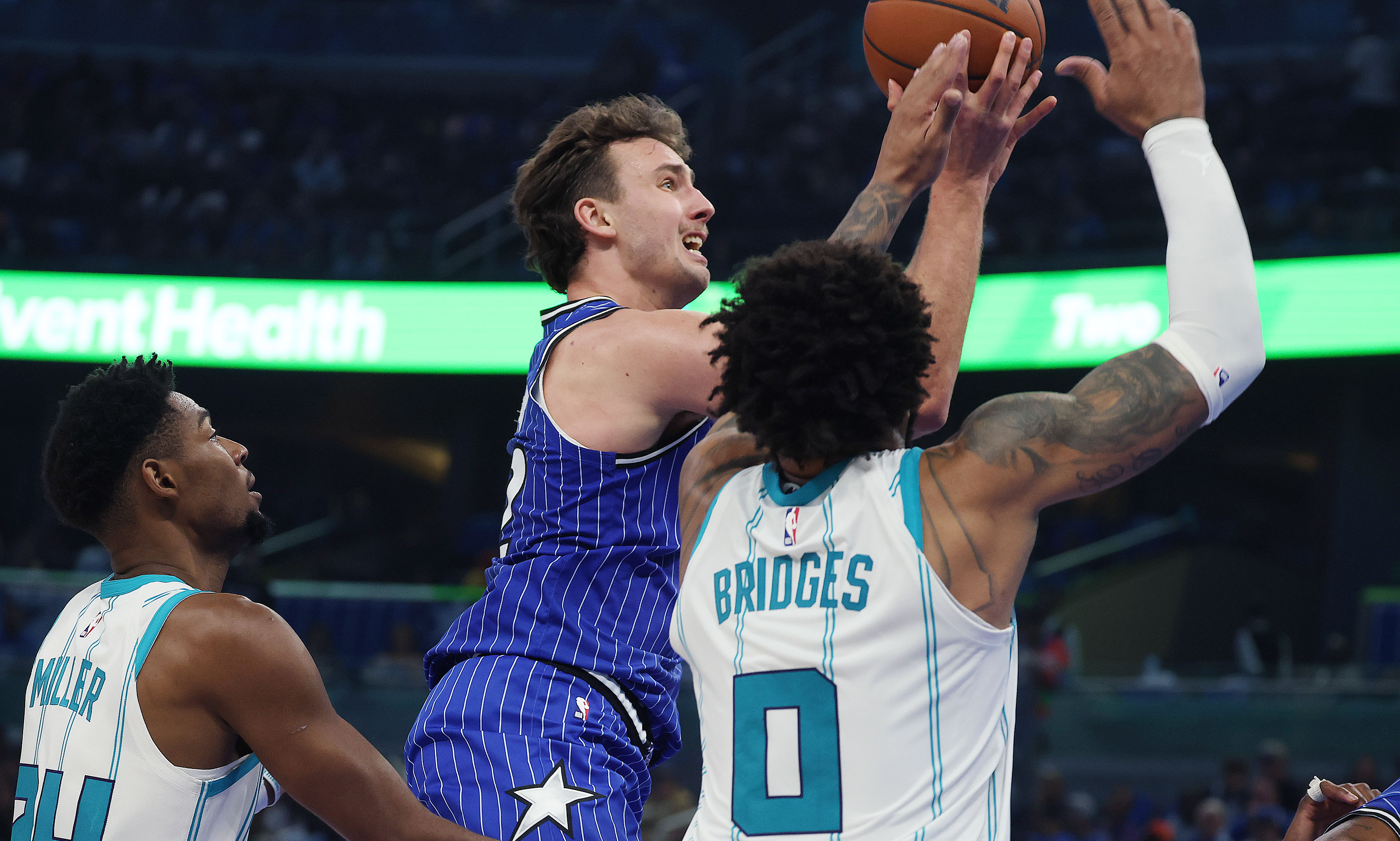 Orlando forward Franz Wagner (middle) scores between Charlotte defenders Brandon...