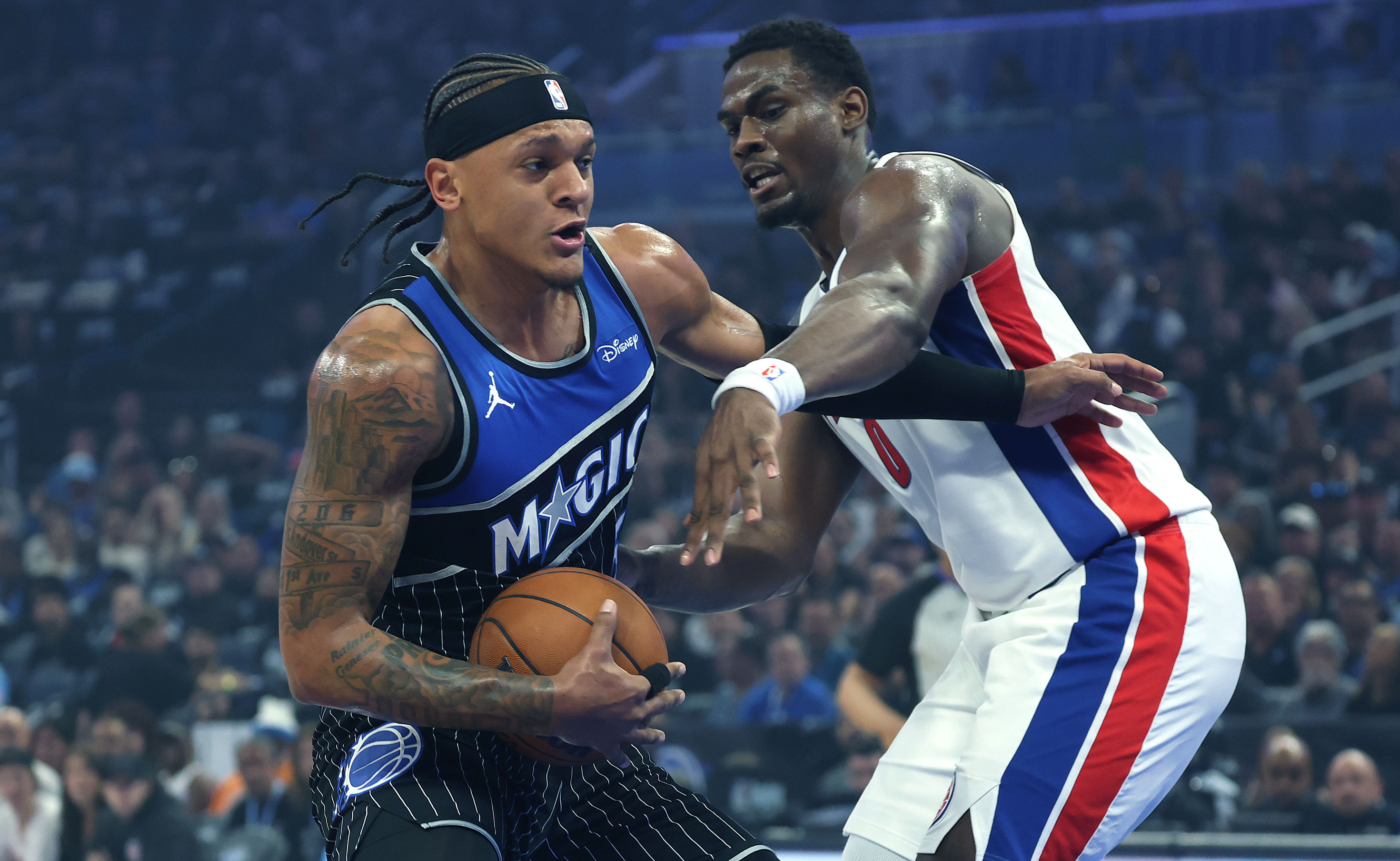 Orlando forward Paolo Banchero (left) drives through Detroit center Jalen...