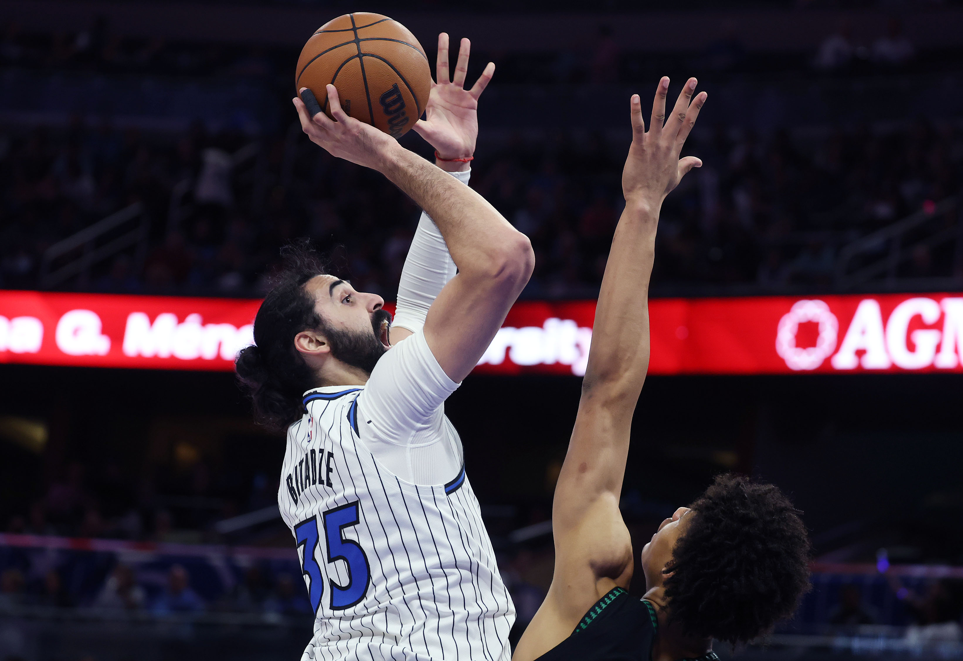 Orlando center Goga Bitadze (35) scores past Minnesota center Joan...