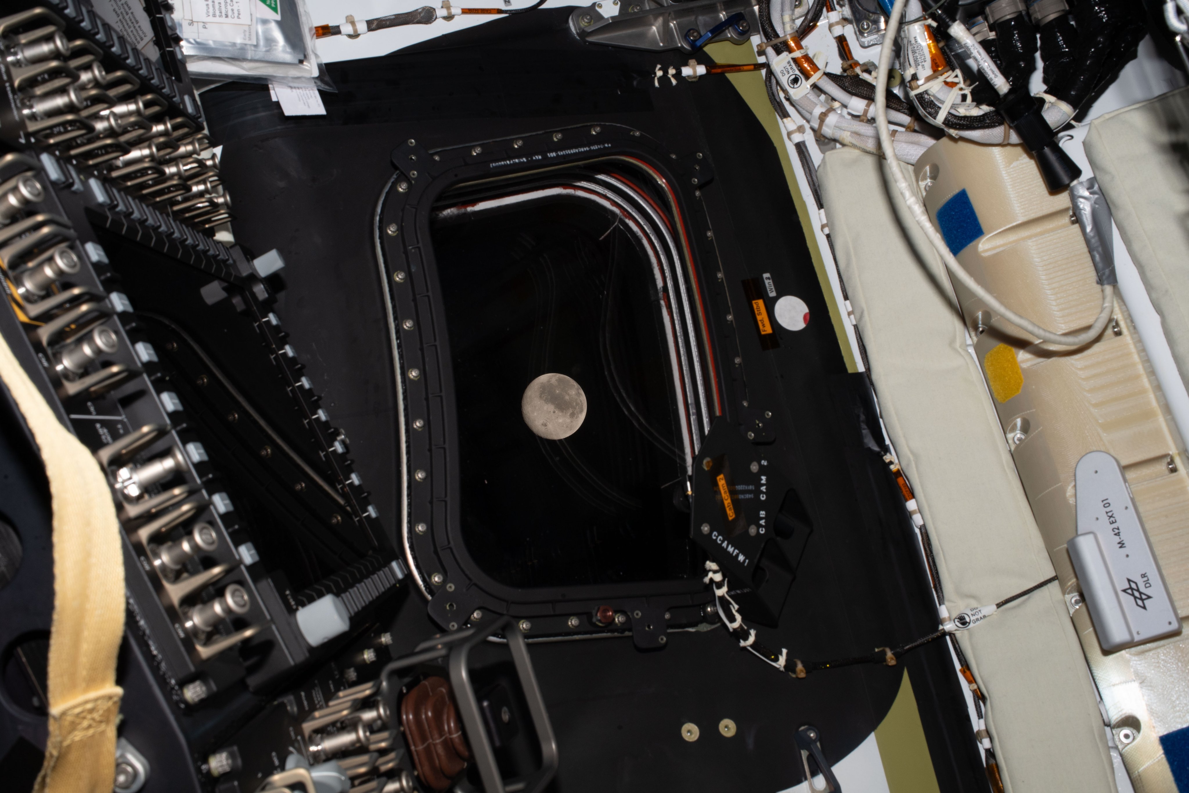 The moon can be seen out a window of the...