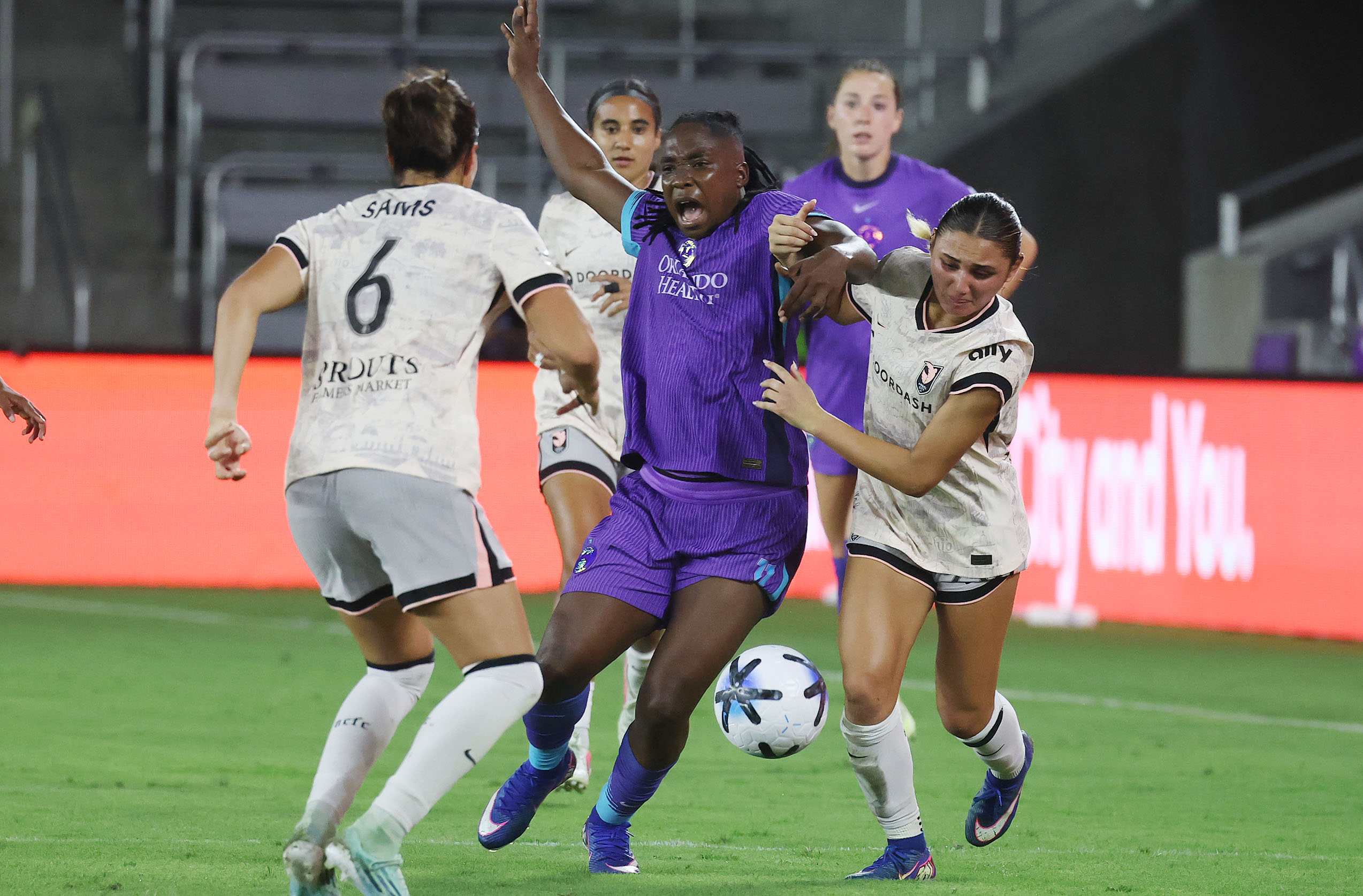 Pride player Barbra Banda (middle) battles Angel City player Emily...