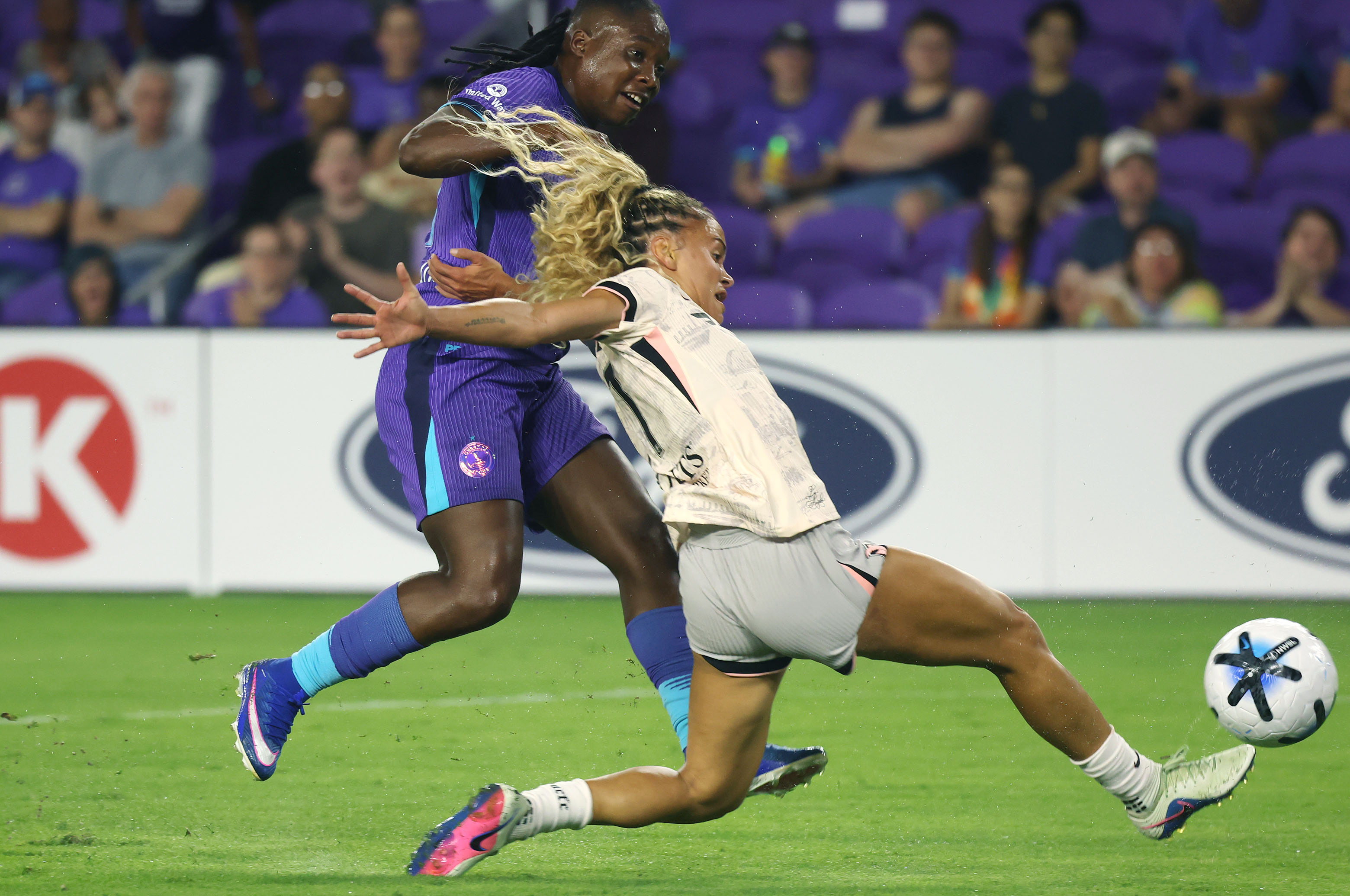 Pride player Barbra Banda (left) kicks past Angel City player...