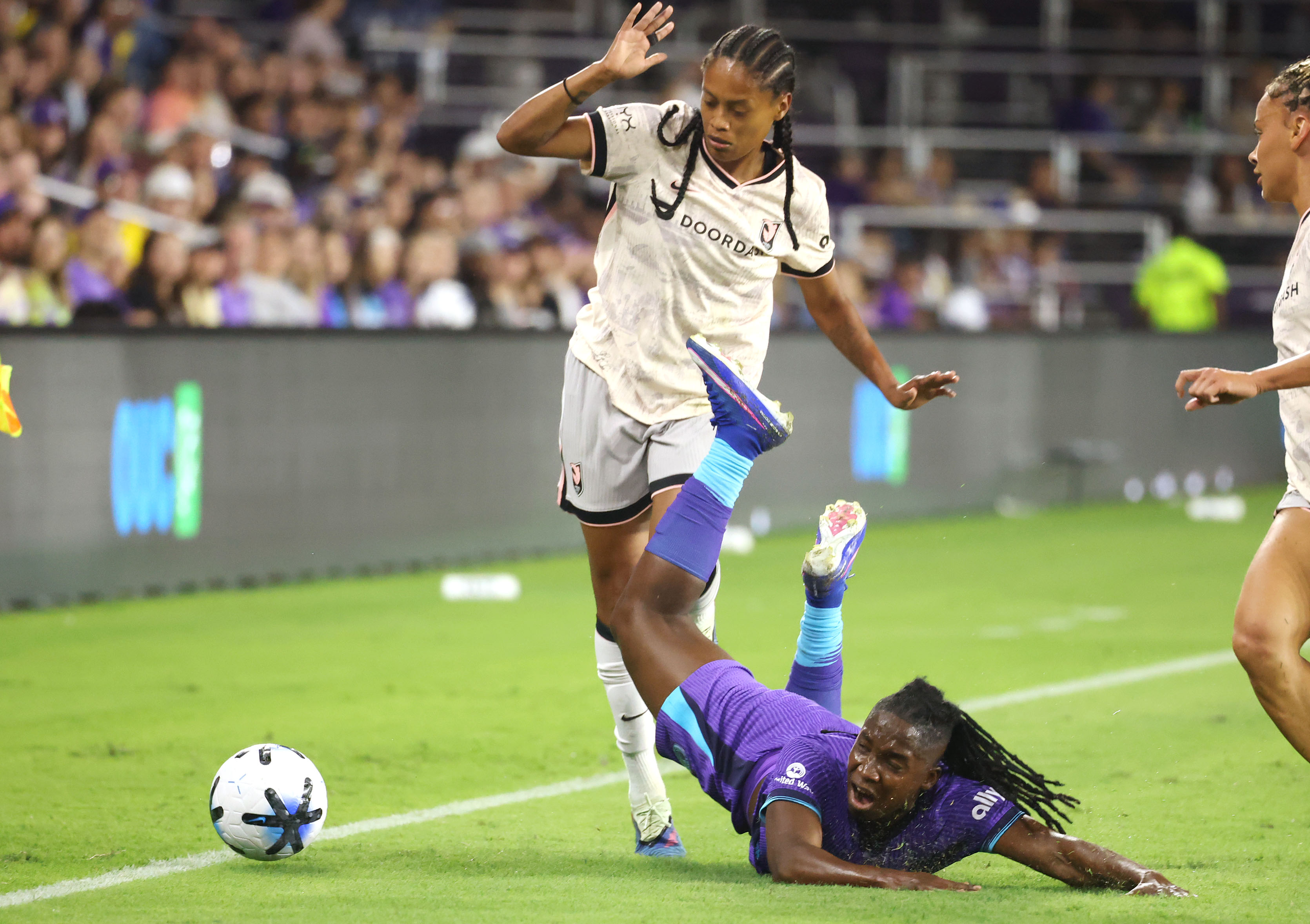 Pride player Barbra Banda (bottom) falls under Angel City player...