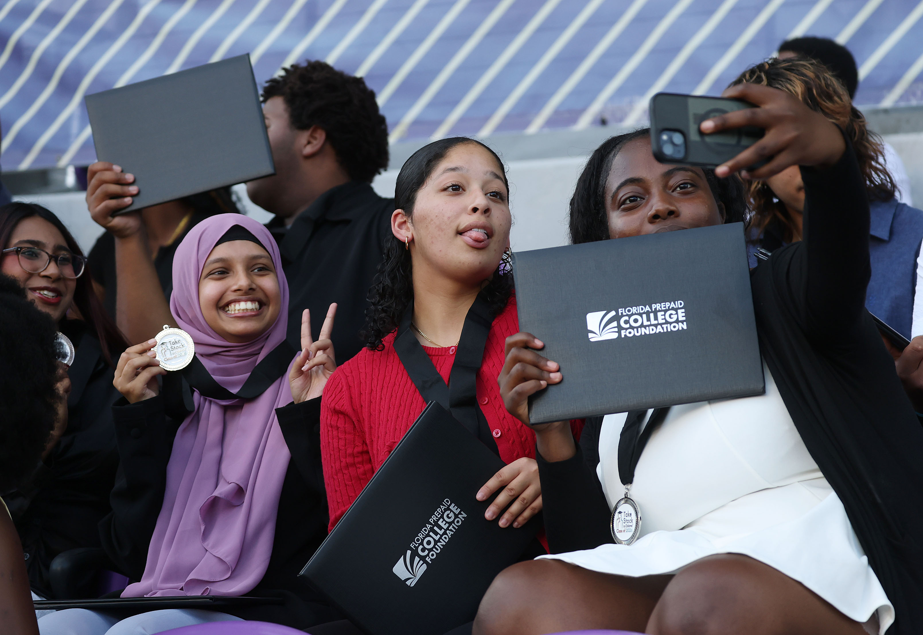 Graduates take photos during the Take Stock In Children Orange...