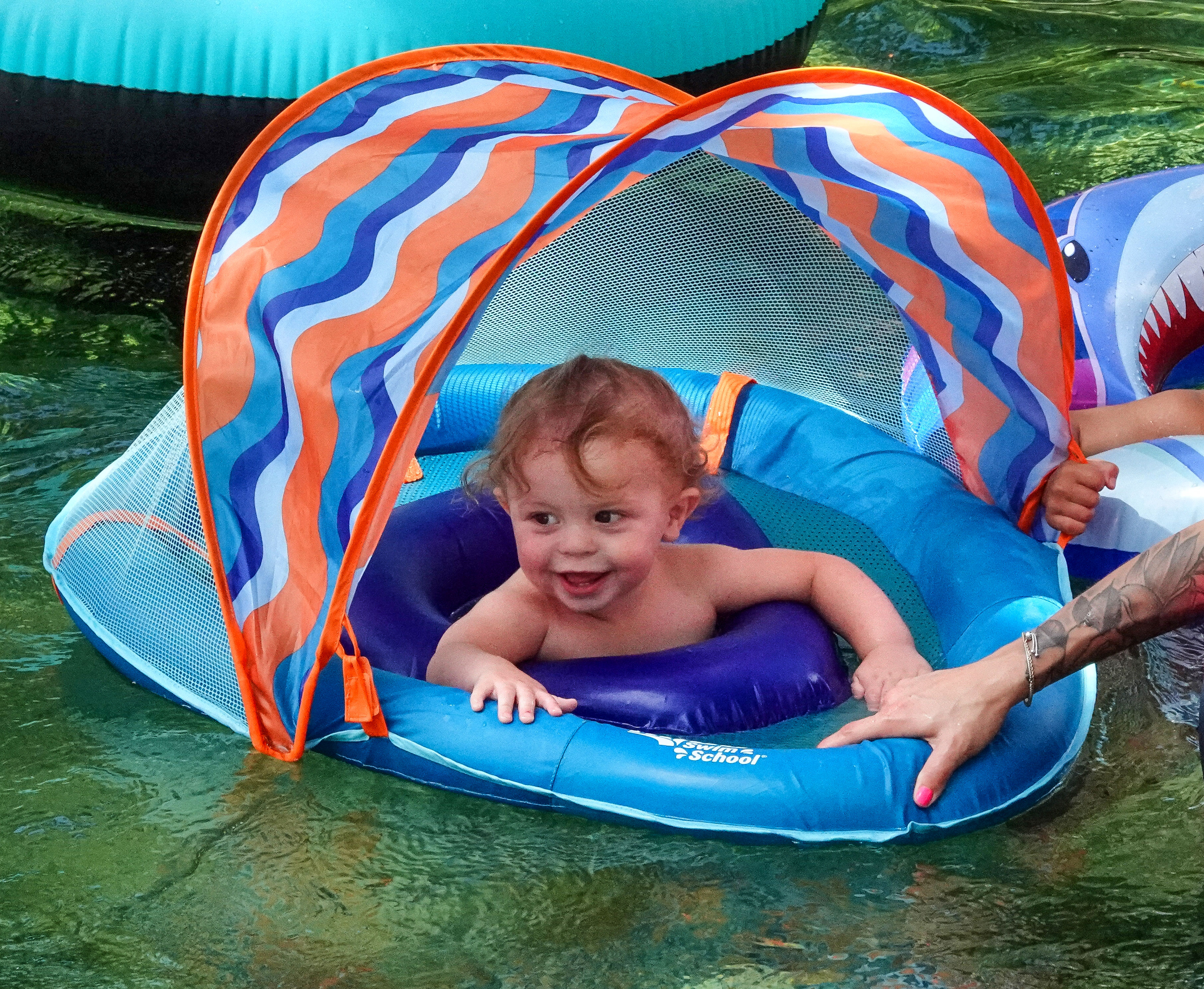 ENJOYING THE BLUE â A young guest enjoys floating down...