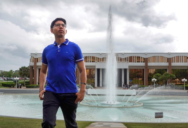 UCF senior Alexander Vallejos walks in front of the school's  iconic reflecting pond, Monday, April 6, 2026. Vallejos is among the DACA students that have been impacted by the Trump administration's immigration crackdown. (Joe Burbank/Orlando Sentinel)
