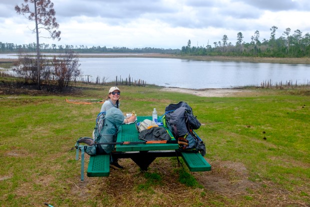 Karissa Bellile pauses at Farles Prairie Recreation Area to eat a Publix sub while hiking the Florida Trail through Ocala National Forest on April 2, 2026. (Patrick Connolly/Orlando Sentinel)
