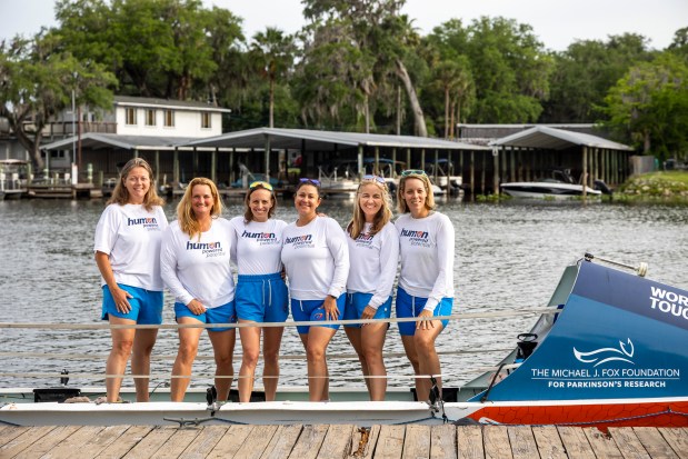 Rowers, from left, Megan Laughlin, Becky Watt, Elizabeth Hall, Andrea Vigil, Maureen Twohig and Ashley Ellis stand together on the American Spirit boat before a training row from Hontoon Island State Park in Volusia County on April 19, 2026. The team plans to row more than 5,000 miles to raise money for Parkinson's research. (Patrick Connolly/Orlando Sentinel)