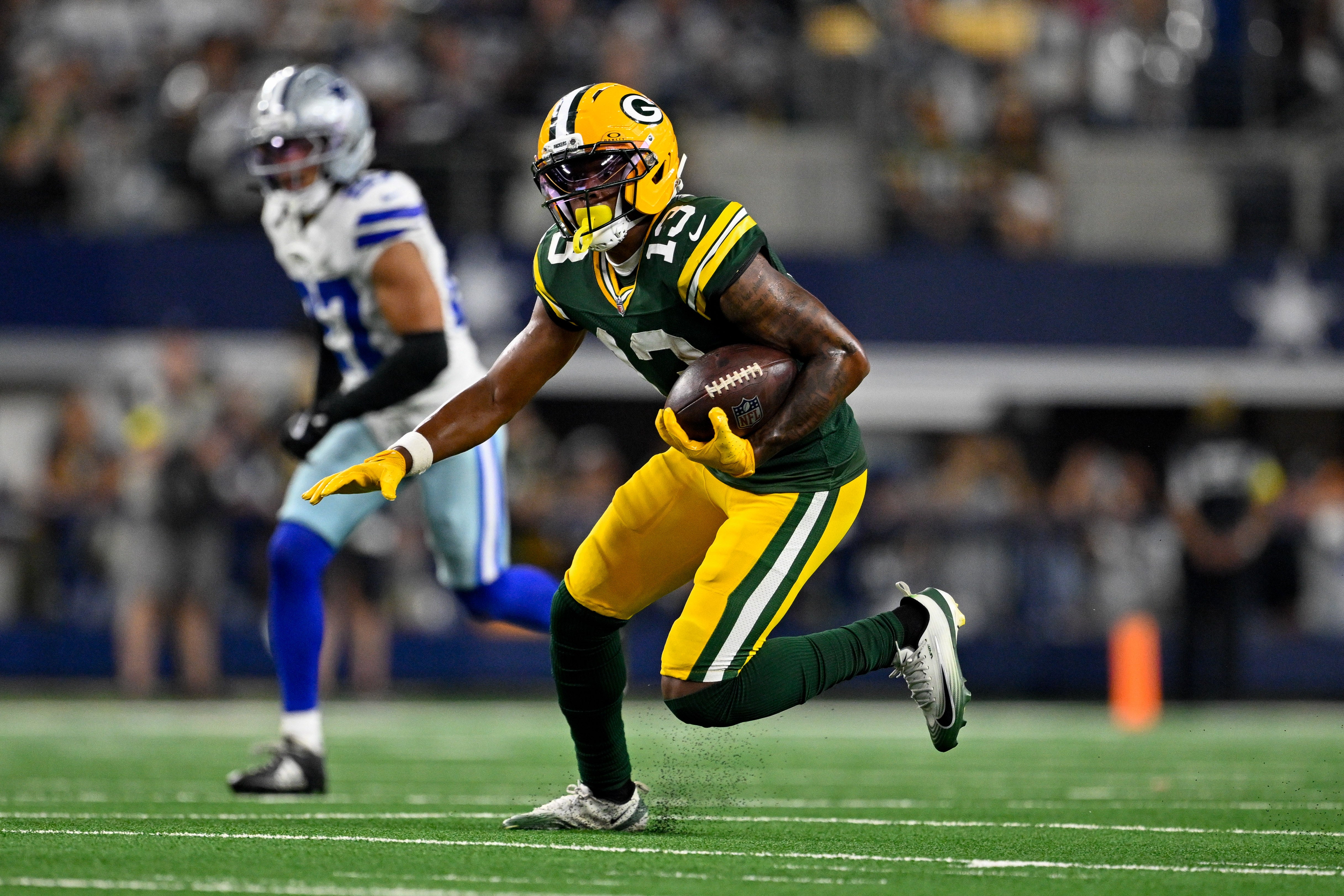 Sep 28, 2025; Arlington, Texas, USA; Green Bay Packers wide receiver Dontayvion Wicks (13) runs with the ball during the game between the Dallas Cowboys and the Green Bay Packers at AT&T Stadium.