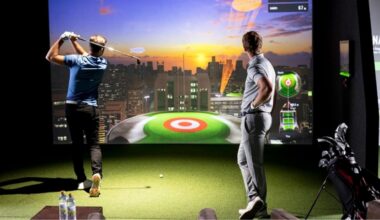 Indoor golf simulator with players hitting shots toward a digital course display
