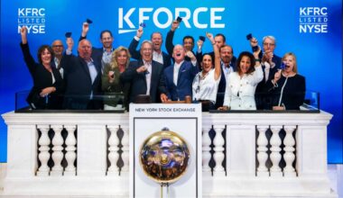 Kforce executives and team members ring the opening bell at the New York Stock Exchange in front of a Kforce-branded display.