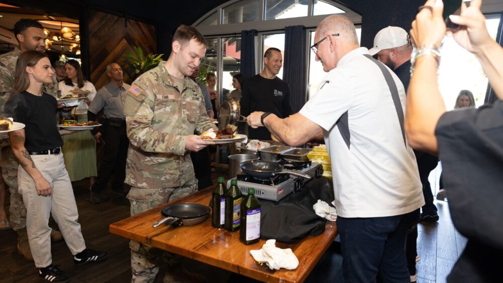 Chef Robert Irvine serves a meal to a U.S. service member during a Tampa Bay Wine & Food Festival event.