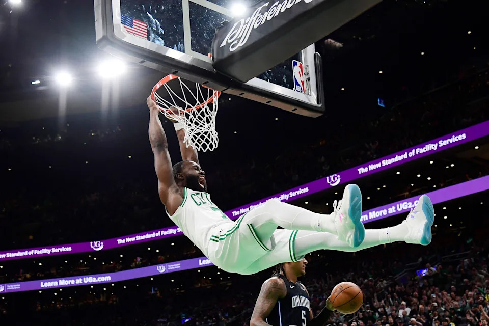 Apr 20, 2025; Boston, Massachusetts, USA; Boston Celtics guard Jaylen Brown (7) hangs on the rim after dunking the ball during the second half against the Orlando Magic at TD Garden. Mandatory Credit: Bob DeChiara-Imagn Images