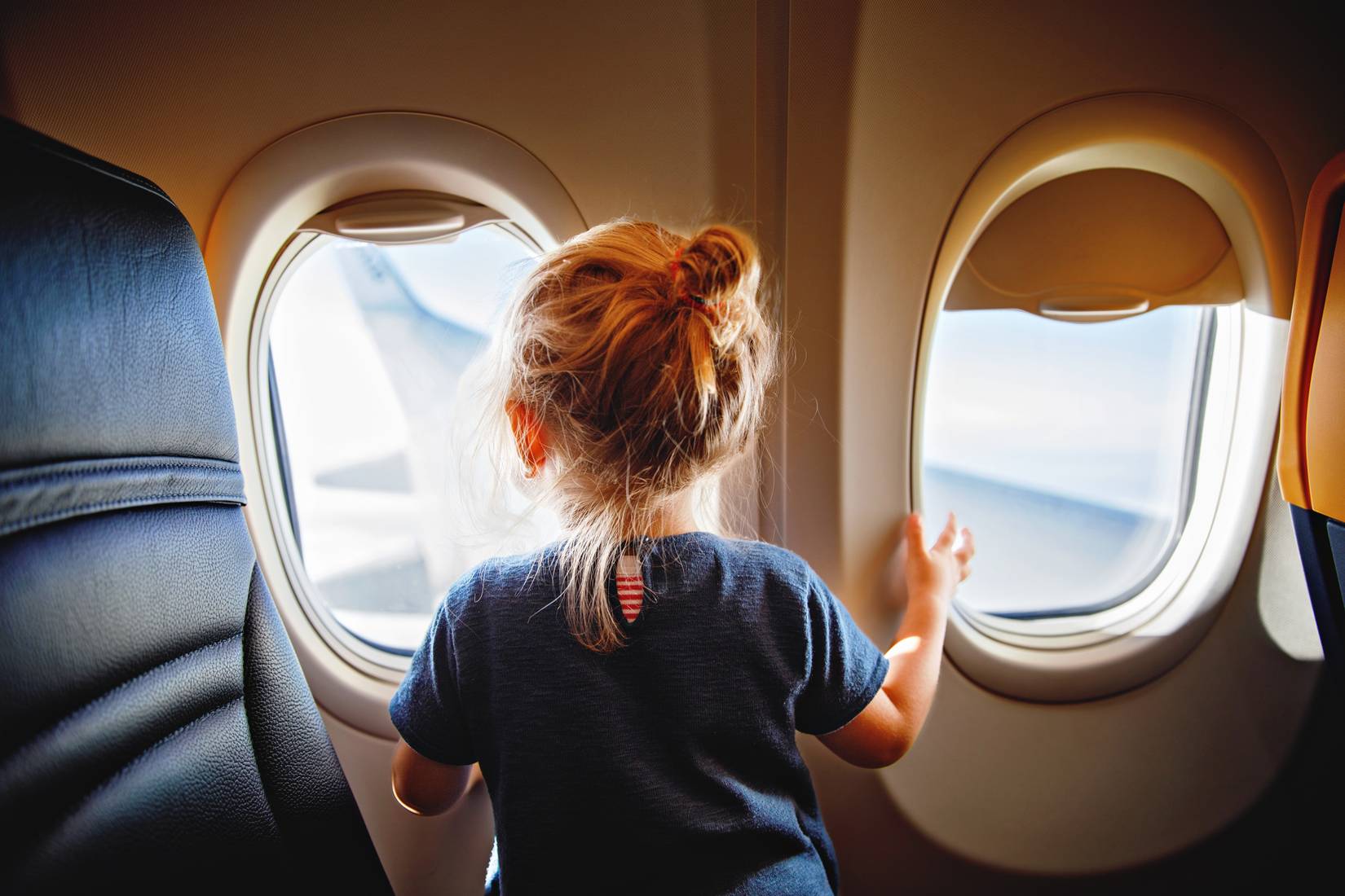 Child sitting next to the window on an aircraft
