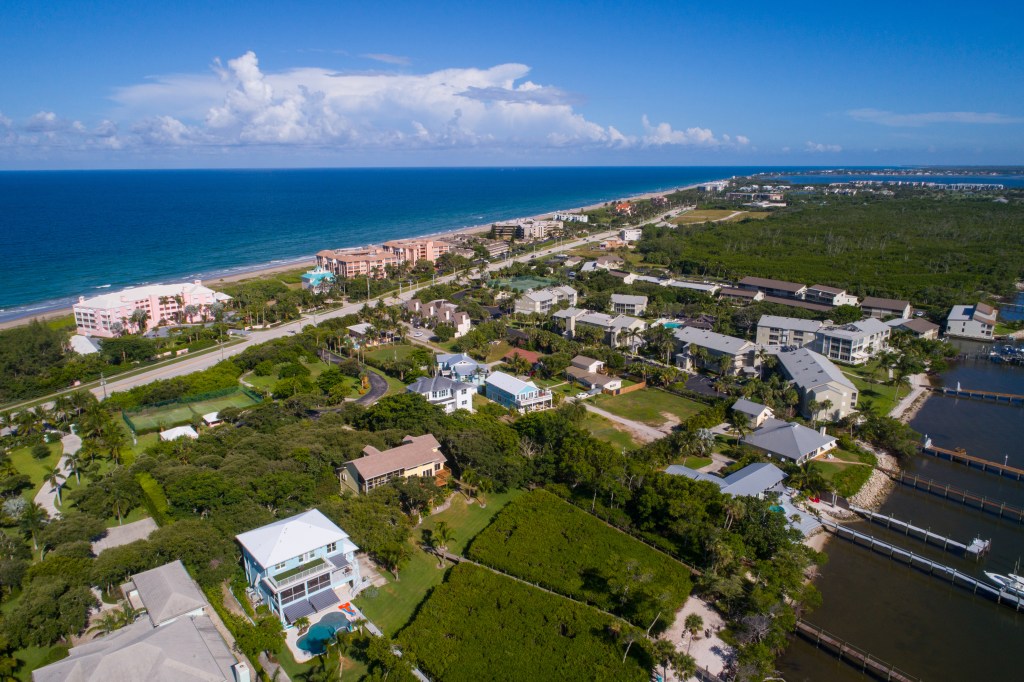 Aerial image of residential properties on Hutchinson Island, Florida, with the Atlantic Ocean on the left and the Indian River Lagoon on the right.