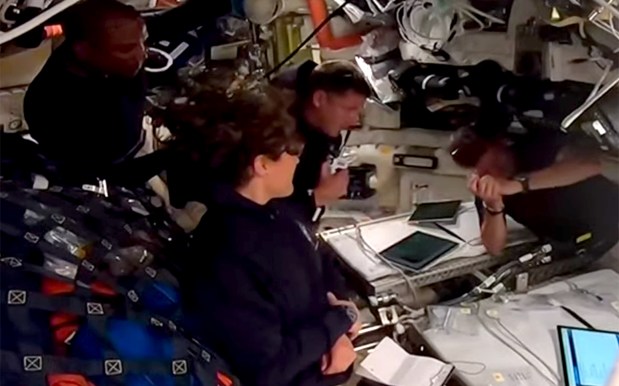 NASA astronaut Reid Wiseman, right, clasps his hands in reaction as Canadian Space Agency astronaut Jeremy Hansen announces the crew's request to name one of two craters on the moon in honor of Wiseman's late wife Carroll on Monday, April 6, 2026. Also in the photo are NASA astronauts Christina Koch and Victor Glover at right. (Courtesy/NASA)