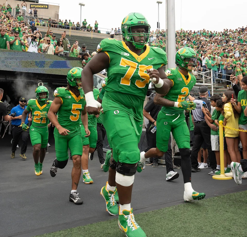 Oregon’s Emmanuel Pregnon, center, takes the field before the game against Oklahoma State at Autzen.
