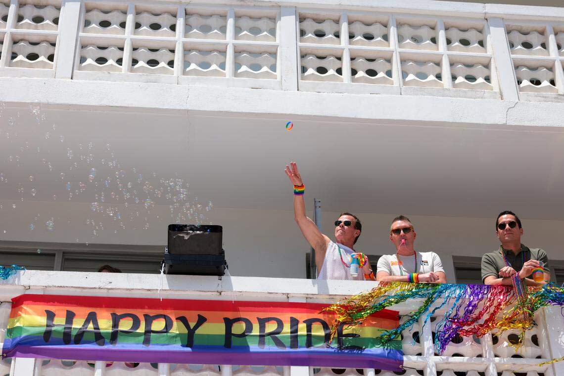 Aman throws a bracelet from a balcony to people parading on Ocean Drive during the 18th annual pride parade in Miami Beach, Florida, Sunday, April 12, 2026.