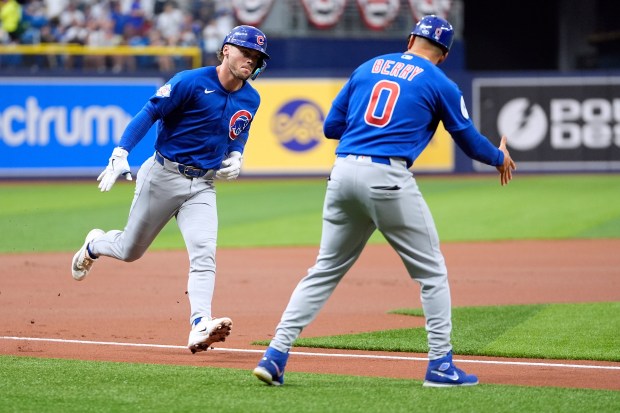 Chicago Cubs' Nico Hoerner celebrates his solo home run off Tampa Bay Rays pitcher Joe Boyle with third base coach Quintin Berry (0) during the first inning of a baseball game Wednesday, April 8, 2026, in St. Petersburg, Fla. (AP Photo/Chris O'Meara)