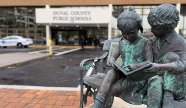 A statue of children reading in front of DCPS headquarters.