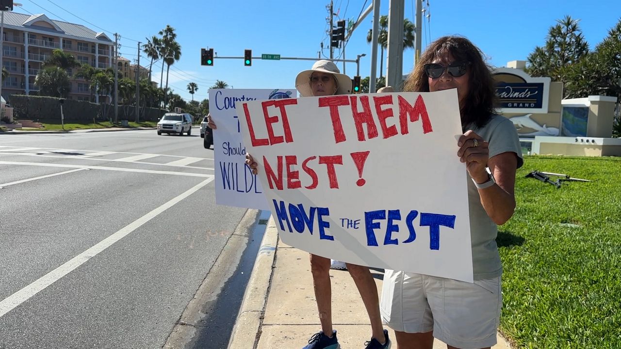 Protesters line up outside of Tradewinds Resort, claiming the Country Thunder Florida will disrupt nesting season of turtles and skimmers. (Spectrum News)