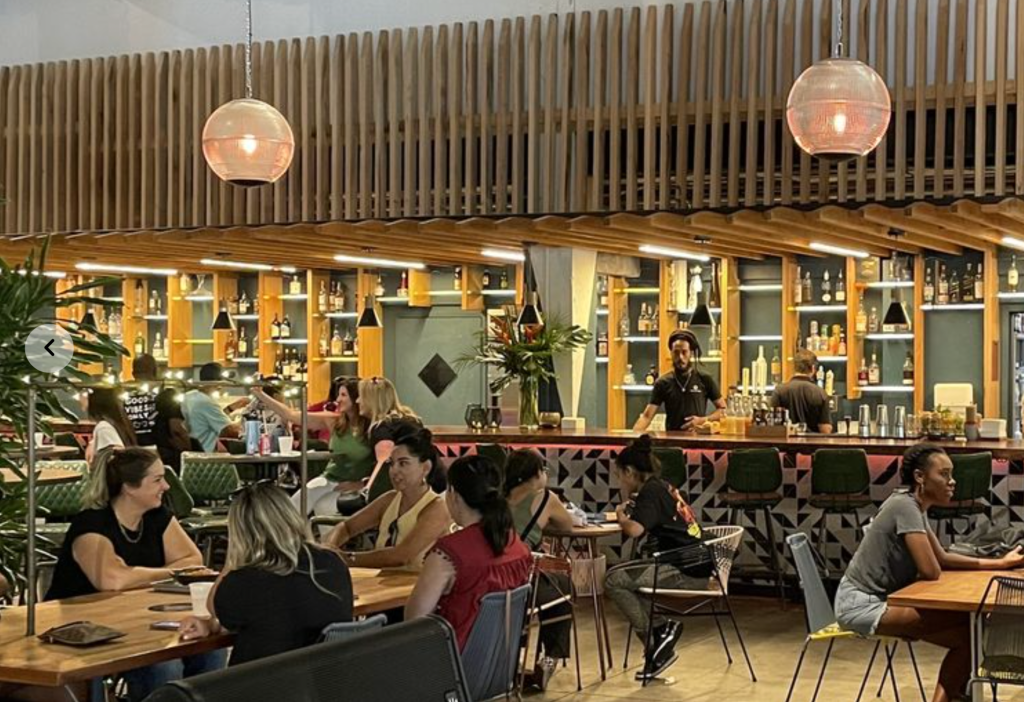 photo of people dancing at tables inside a food hall