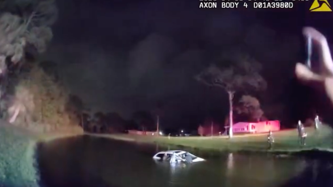 Port St. Lucie Police officers rescue an elderly couple from a vehicle that became partially submerged in a pond after crashing during heavy downpours on April 8.