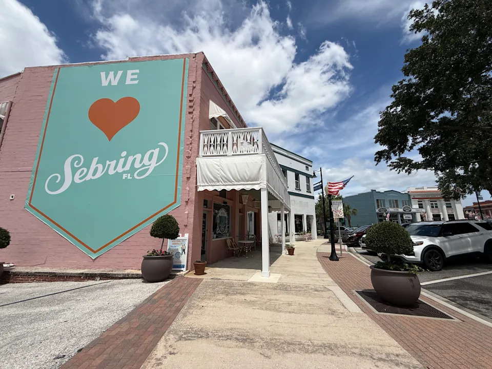 Teal Sebring mural against a pink wall. 
