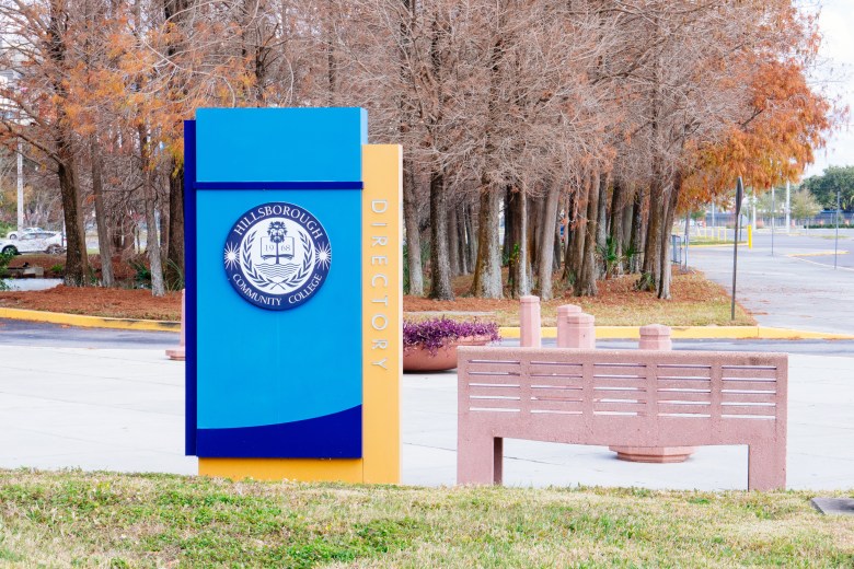 Hillsborough Community College Dale Mabry Campus entrance sign with blue and yellow directory, autumn trees, and school logo in Tampa, Florida.