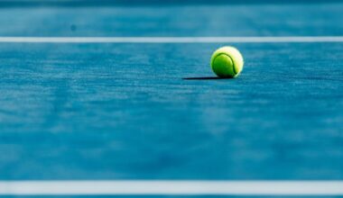 A lone tennis ball on a blue court with white lines