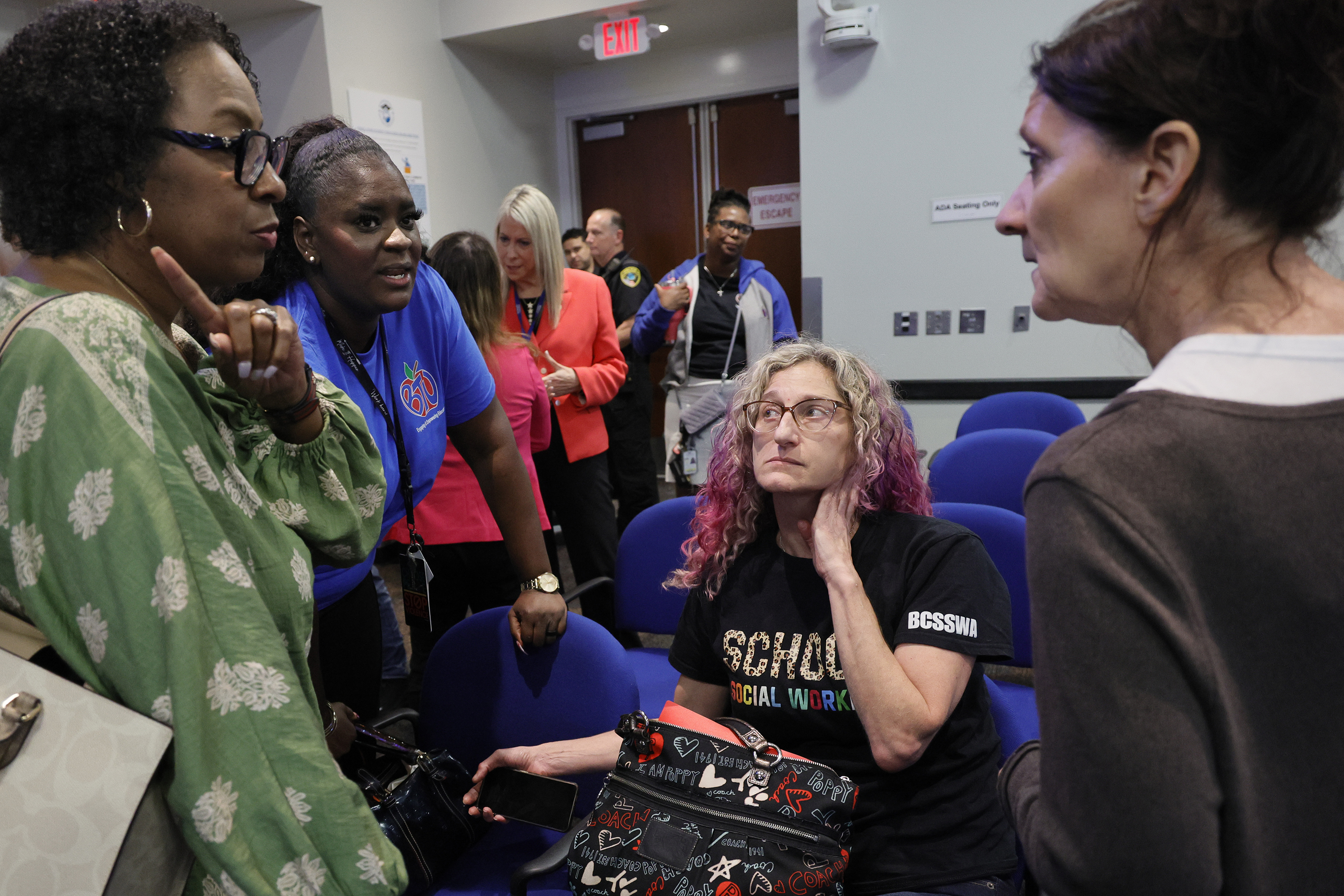 School social workers, from left, Tanya Ivy, Latoya Richards, Melanie Birken, and ESE Advisory Chair Jacqui Luscombe, of Coral Springs, have a lively discussion during a brief break in a Broward County School Board workshop about proposed cuts to about 350 jobs across the district on Tuesday. (Amy Beth Bennett / South Florida Sun Sentinel)