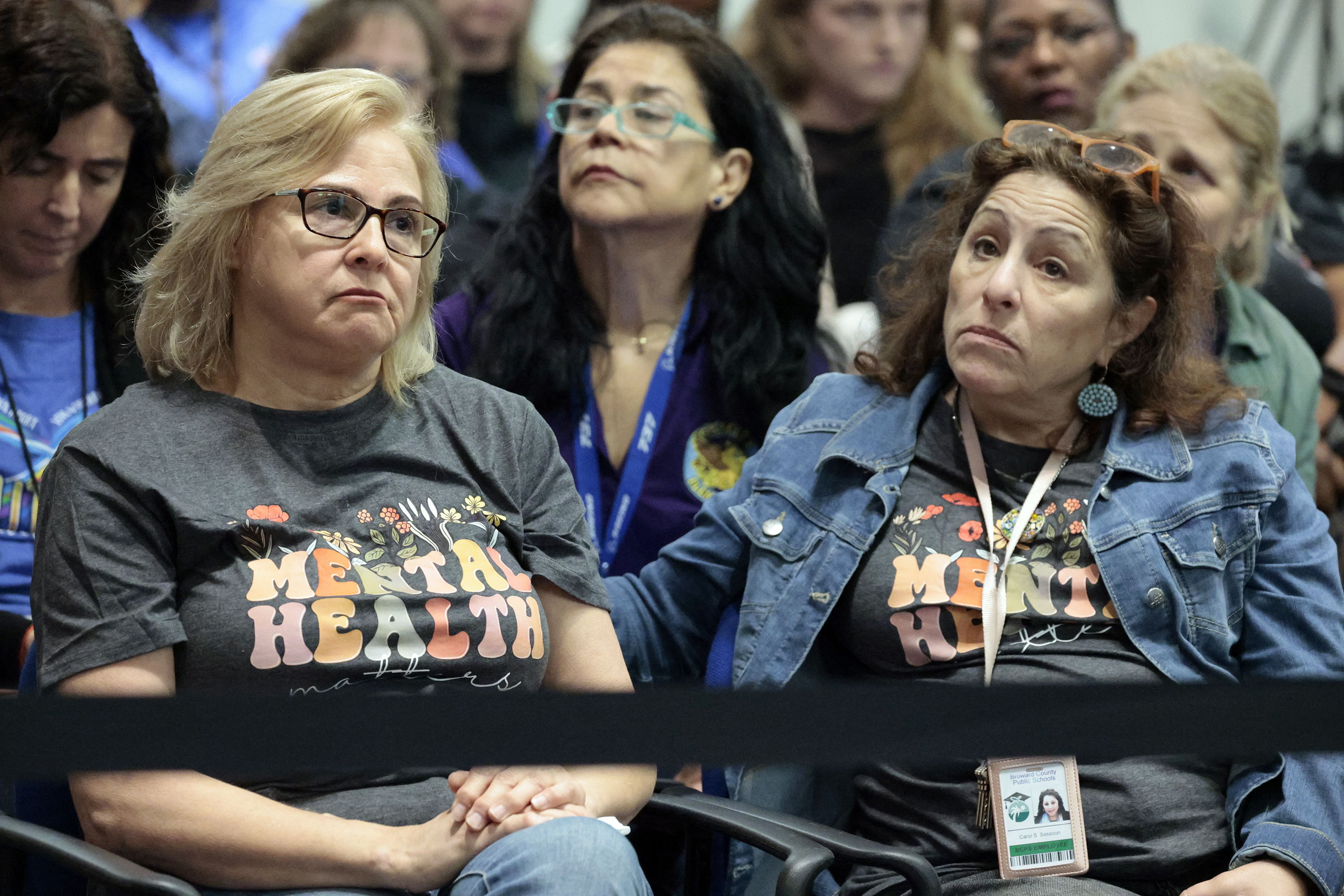 Audience members react to public comments during a Broward County...