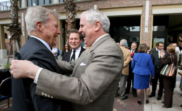 Orlando Chamber of Commerce president Jacob Stuart (right) celebrates with Charles Gray (left) and Fred Leonhardt (background) as Governor Charlie Crist prepares to sign the Sunrail bill during a ceremony at Church Street Station in downtown Orlando, Wednesday, December 16, 2009. The ceremony in Orlando was one of four during Crist's statewide fly-around, Wednesday, with similar signings in Tallahassee, Tampa and Fort Lauderdale. (Joe Burbank/Orlando Sentinel file)