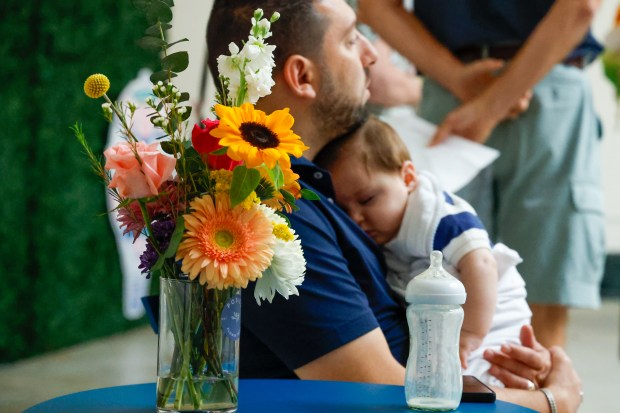 A young one with their dad takes a little bit of rest from wandering the Art in Bloom displays at the Orlando Museum of Art on Friday, April 10, 2026. (Rich Pope/Orlando Sentinel)