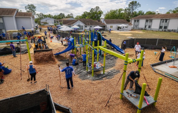 The Orlando Neighborhood Improvement Corporation, with volunteers from the Orlando Magic Champions of the Community Partners and KABOOM!, build a kid-designed playground at the Boca Club Apartments on Thursday, April 2, 2026. (Ricardo Ramirez Buxeda/ Orlando Sentinel)