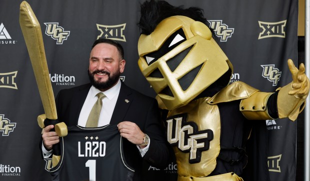Gabe Lazo, the new UCF women's basketball coach, poses for photos with Knightro after the press conference to introduce him, on Thursday, April 9, 2026. (Ricardo Ramirez Buxeda/ Orlando Sentinel)