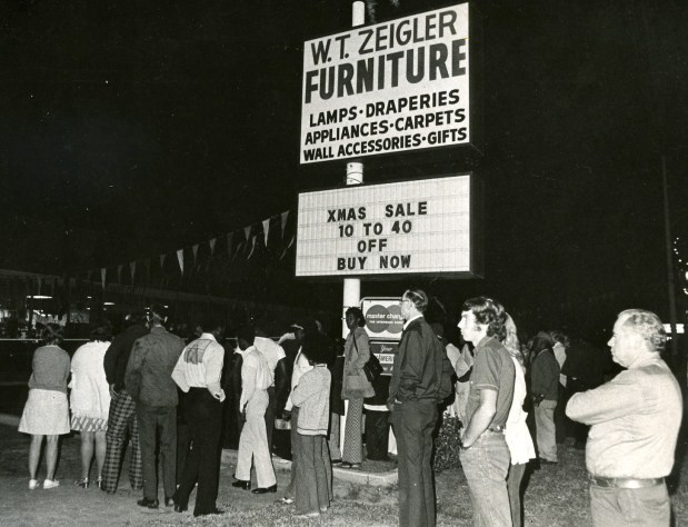 Area residents gather in from the W.T. Furniture store in 1975 after four people were found shot to death on Christmas Eve. Owner of the store, W.T. "Tommy" Zeigler, who was shot but survived that night, was convicted of the murders. (Orlando Sentinel file, 1975)