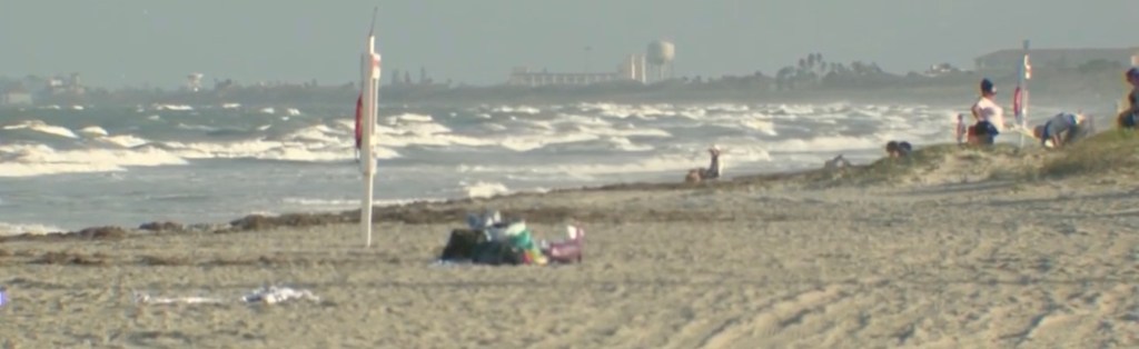 A rough ocean at Cocoa Beach, Florida, with several people near the shore.