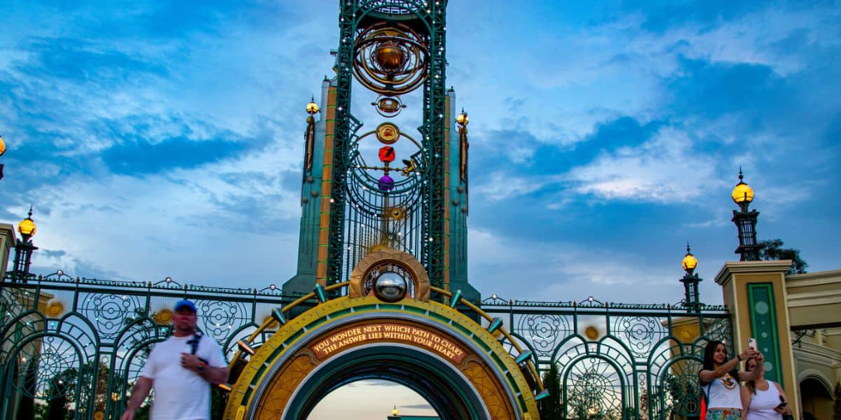 Guests snap photos by Universal Orlando’s glowing clock tower gate, buzzing with anticipation for the Epic Universe expansion. Epic Universe Harry Potter expansion
