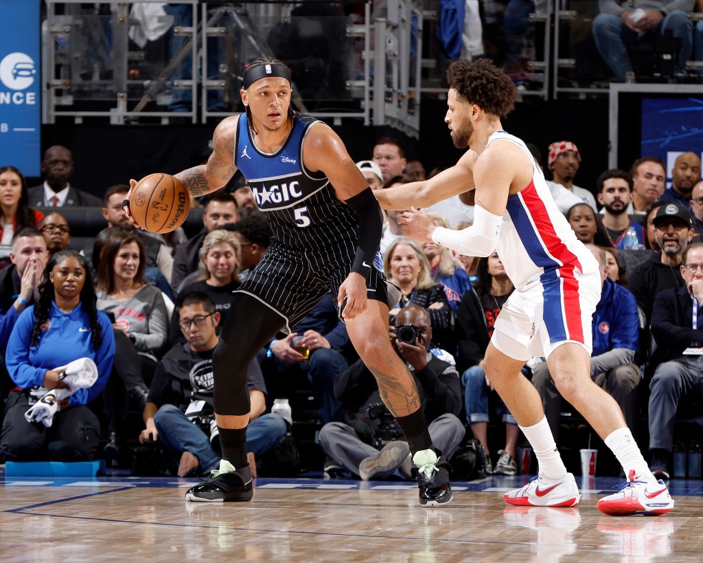 Paolo Banchero of the Orlando Magic dribbles the ball while Cade Cunningham of the Detroit Pistons defends him.