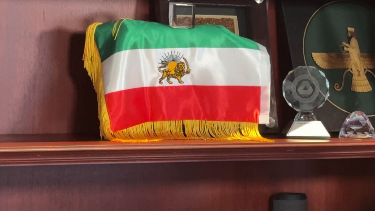 A lion and sun flag sits in the office of former Iranian America Community Center President Pooyan Balouchian. (Spectrum News)