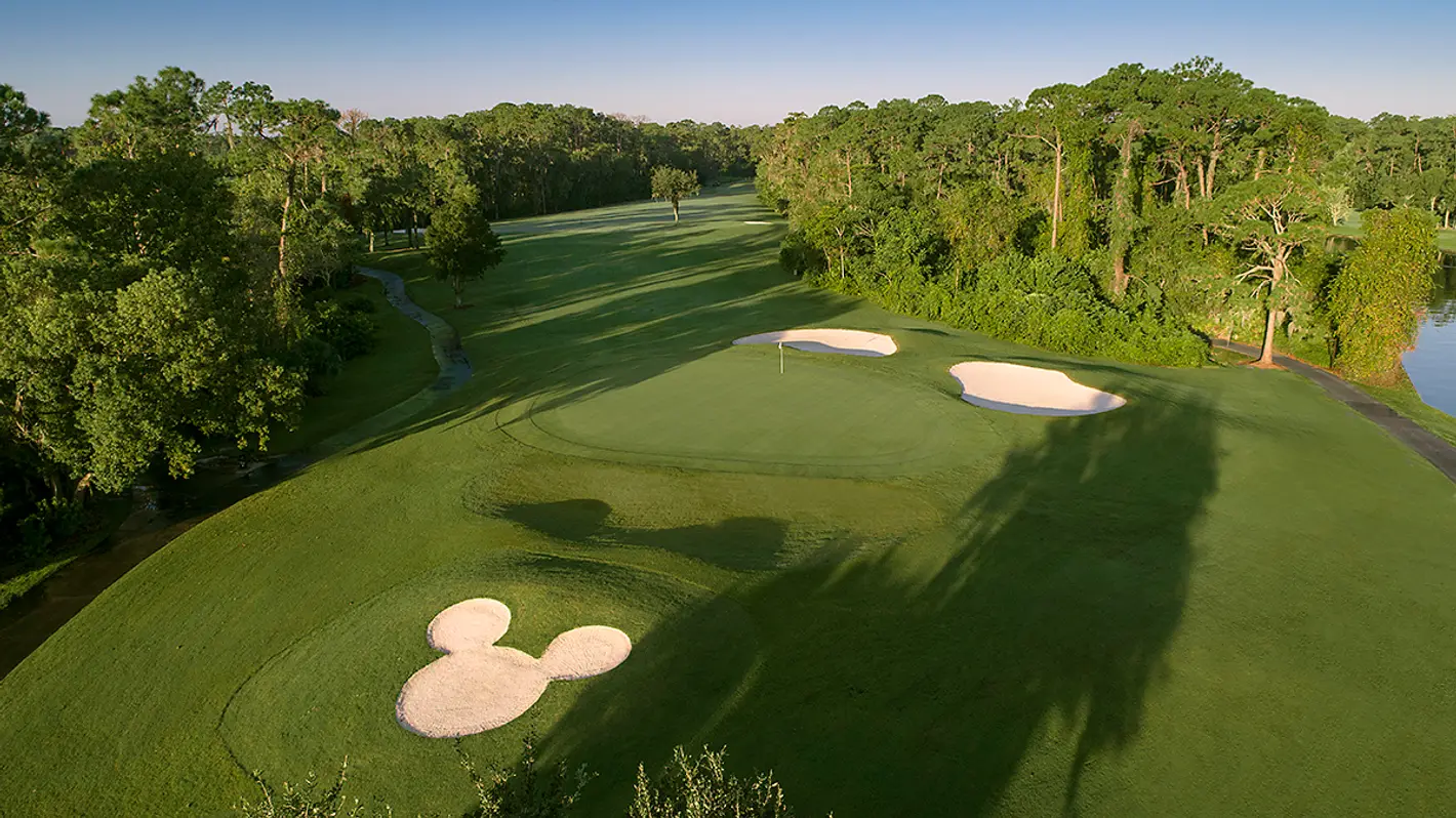 Aerial view of Lake Buena Vista Golf Course at Walt Disney World. The overhead shot shows the green course and a Mickey-head shaped sand trap;