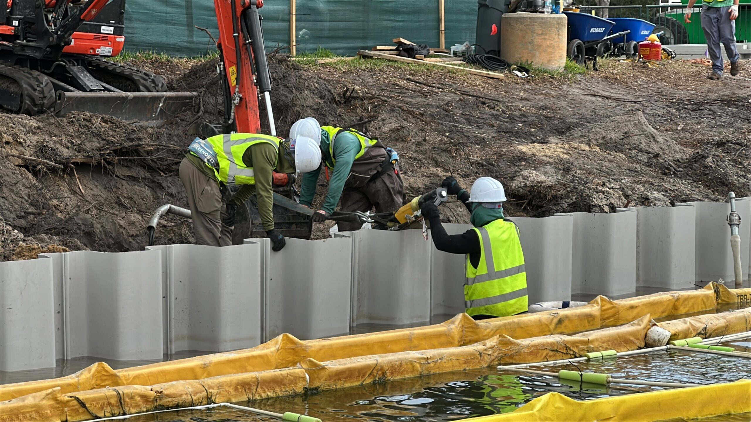 A group of crew members was securing part of the new wall as we sailed past. An excavator was used to move dirt out of the way.